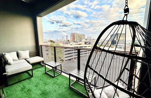 Westside Apartment | Ceiling to floor windows featuring a private balcony with stunning city views! n