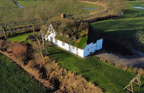 Poppenbull House | Dream house under thatch with fireplace, sauna, wellness room and lots of space
