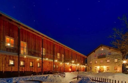 Bohmzwiesel Apartment | Ferienchalet mit überdachter Veranda mit Lounge Möbel und Schwebeliege.