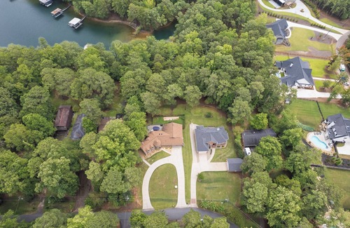 Flowery Branch House | Lakefront 4BR/6BA home with private dock, fire pit, smart TVs in all rooms, sunroom, BBQ grill, and fenced game yard. Includes golf cart, 2 fridges, double oven, and more. 1 mile to Aqualand Marina & Pig Tales Restaurant.