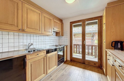 Verbier Apartment | Living room with fireplace and eating corner, kitchen with 3 hotplates and dishwasher, one bedroom
