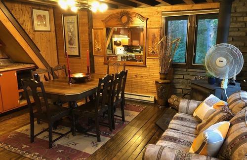 Cap-Pele Ski Chalet | Luxurious rustic wooden chalet on edge of tranquil pond in nature next to beach.