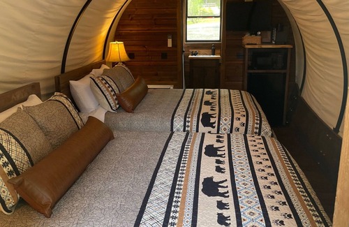 Branson Cottage | Oregon Trail Wagon has two queens size bed, bathroom w/shower, heat & a/c, smart tv, wi-fi, microwa
