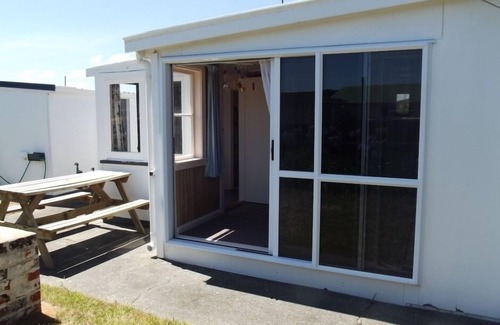 Foxton Beach House | Quaint comfortable convenient well appointed family bach.