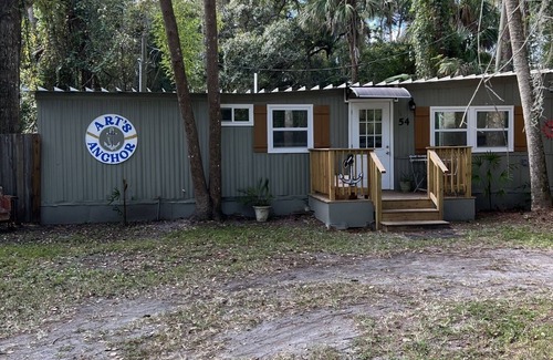 Inglis Apartment | Step into this cozy 2-bedroom cabin nestled in the tranquil woods. The main living area offers comfy seating, including a pull-out futon for additional sleeping space. An efficiency kitchen awaits your culinary adventures, equipped with essentials fo