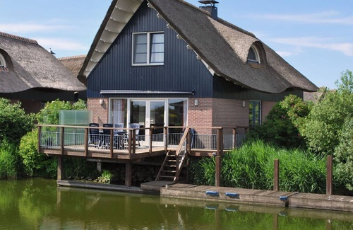 Makkum Villa | Thatched villa with terrace on the water at a holiday park in Friesland