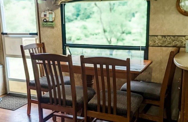 Camper in middle of farm setting with creek view