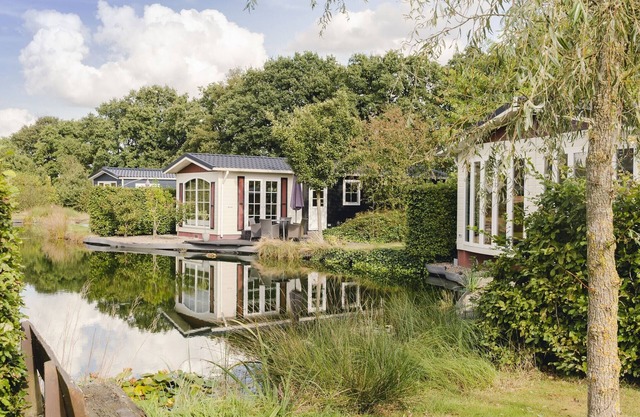 Comfy chalet with a dishwasher, directly on a pond