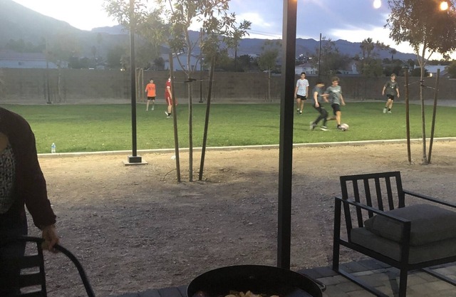 Modern container home in Las Vegas with own soccer field and trees.