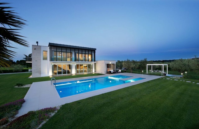 Modern villa with swimming pool surrounded by greenery