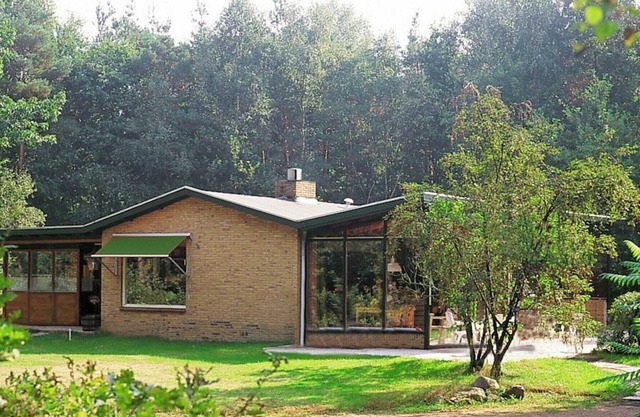 Neatly furnished bungalow with fireplace in a holiday park with a green location