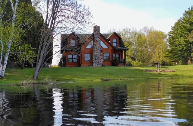Stunning log home with a rental pontoon on a quiet sunlit bay. Check it out!