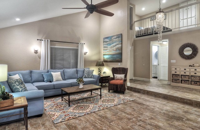Sunny condo with loft and spacious patio surrounded by palm trees