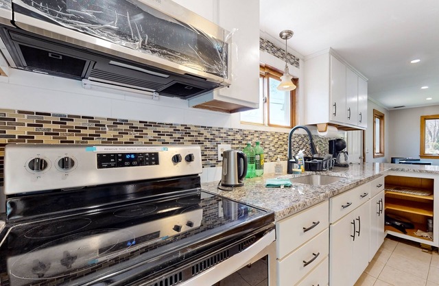 Two-story dog-friendly home with a lake view, deck, gas grill